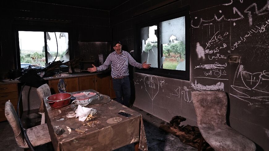 A Palestinian man stands inside his kitchen in the aftermath of an attacked by Israeli settlers